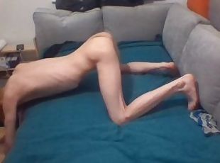 Skinny blonde teen stretches his body out on sofa and shows off ribs