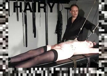 Girl on his table is bound and covered in hot wax