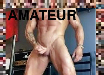 Bodybuilder with forearm sleeve strokes thick cock and practices posing and flexing muscles