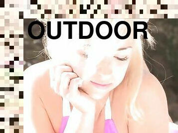 Sexy blonde reads a magazine butt naked outdoors