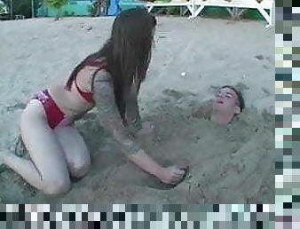 mistress plays with slave in a beach