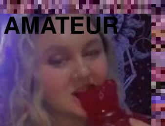 seductive teen takes a bite out of a giant gummy bear