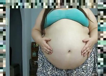 Obese woman puffs up and plays with her gigantic belly
