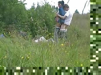 A lusty couple fucking in a field