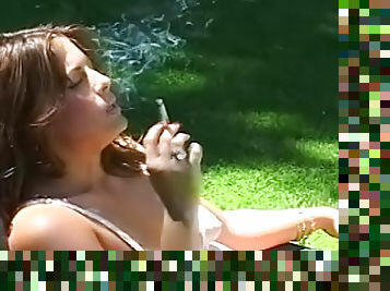 Sweet babe is lying in the garden and smoking