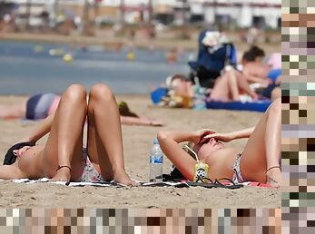 Hot chick and her friend go topless on a beach