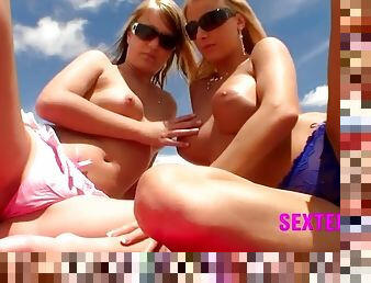 Babes lotion up their tits on the beach