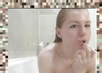 Cute ginger girl gets undressed and takes video in bathtub