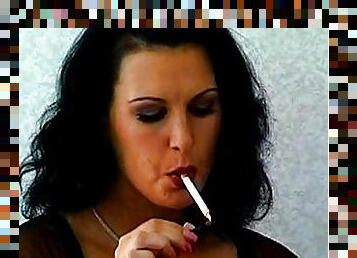 Dark-haired milf is smoking a cigarette