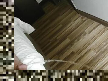 Long piss on carpet from bed in hotel room with fart