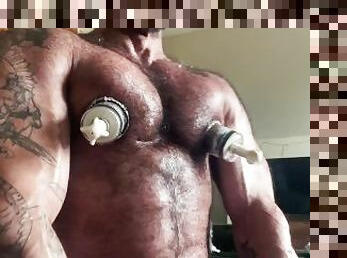 Muscle Daddy uses his nipple suckers and dick pump.